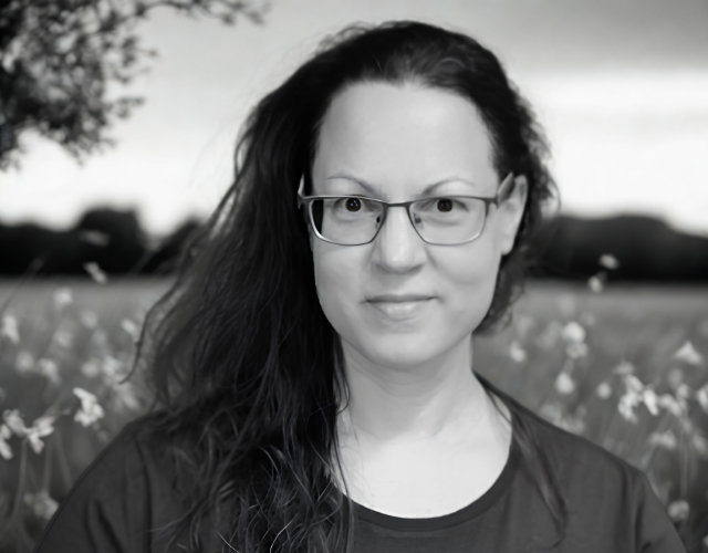 A professional, warm, and authentic portrait of a female life coach in a bright, modern, and serene setting. She radiates calmness, empathy, and professional competence. The background is soft and minimalist with natural light and hints of greenery, representing mindfulness and resilience. High-quality photography style.